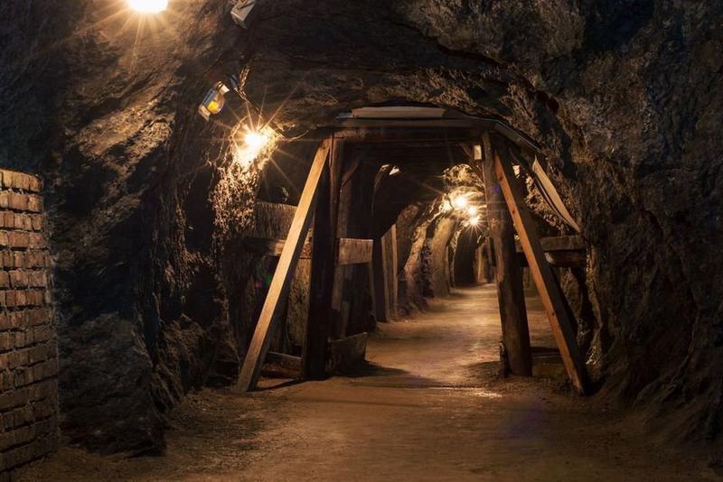 Long lighten tunnel through gypsum mine with wooden beams