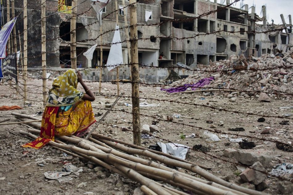 La madre de una trabajadora desaparecida de 18 años, Rina, espera a su hija perdida frente a una barricada en Savar, Dhaka, Bangladesh, 24 de julio de 2013. Crédito Taslima Akhter.