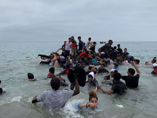 Un grupo de personas se hace con una embarcación de las autoridades marroquíes en la playa de Fnideq (Castillejos) para cruzar los espigones de Ceuta. (EFE/Archivo/Mohamed Siali)