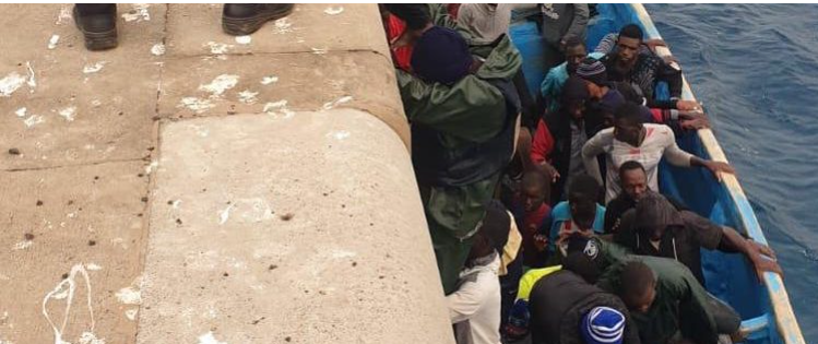 Migrantes en patera arrimados al dique del puerto de Arguineguín. (Foto Maspalomasahora.com).