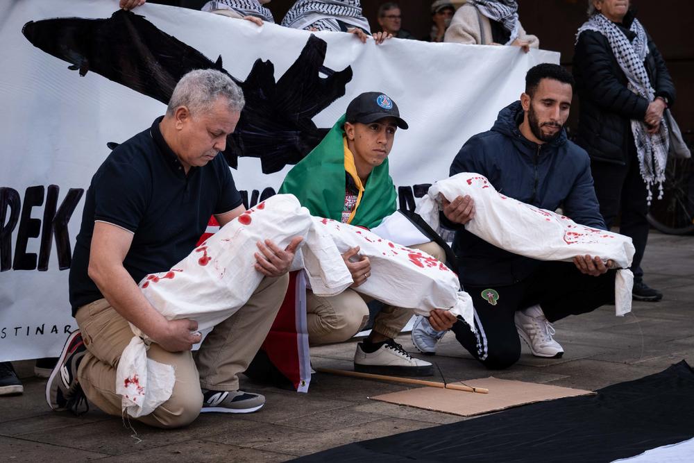 Varios manifestantes palestinos sujetan una simulación de cadaveres de bebes asesinados por Israel al final de la manifestación - Javi Julio