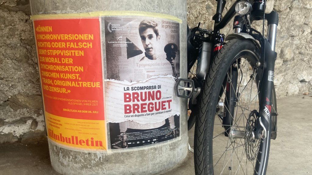 Afiche anunciando el documental de Olmo Cerri en una calle de la ciudad italiana de Locarno