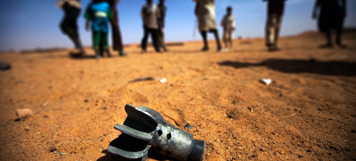 Las 100 grandes empresas de armas en el mundo siguen lucrando con el aumento de conflictos.  Un grupo de niños mira los restos de un obús en Sudán. Foto Albert González Farran_ UNAMID