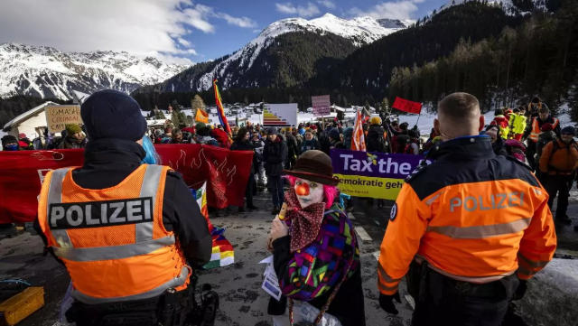 Agentes de policía intervienen ante manifestantes, concentrados frente al Foro de Davos. / MICHAEL BUHOLZER. EFE