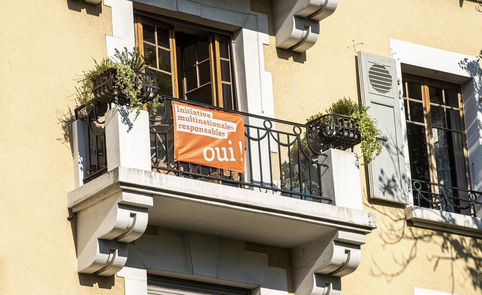 En muchos balcones y ventanas de casas de toda Suiza han sido desplegadas las banderas anaranjadas típicas de la Iniciativa Popular por Multinacionales Responsables. Foto KOVI