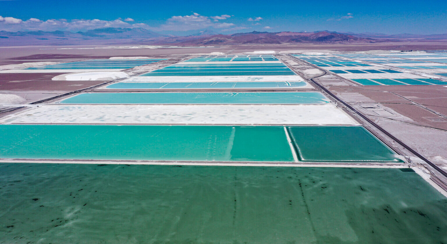 Vista aérea de estanques de salmuera y áreas de procesamiento de la mina de litio de la empresa chilena SQM -en la que la china Tianqi Lithium tiene una participación minoritaria- en el desierto de Atacama, Calama, Chile, 12 de septiembre de 2022. (Foto: Martin Bernetti/AF Aerial view of brine ponds and processing areas of the lithium mine of the Chilean company SQM (Sociedad Quimica Minera) in the Atacama Desert, Calama, Chile, on September 12, 2022. - The turquoise glimmer of open-air pools meets the dazzling white of a seemingly endless salt desert where hope and disillusionment collide in Latin America's "lithium triangle." A key component of batteries used in electric cars, demand has exploded for the "white gold" found in Argentina, Bolivia and Chile in quantities larger than anywhere else in the world. (Photo by Martin BERNETTI / AFP)