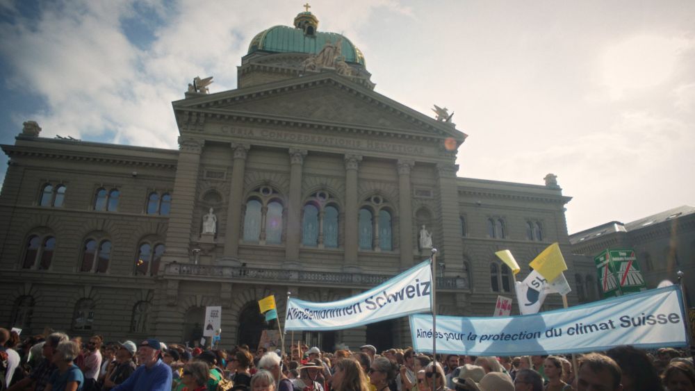 Escena del film TROP CHAUD de una manifestación de las Ancianas por el Clima frente a la Casa de Gobierno en Berna,Suiza. Foto-MattoGrosso Films.