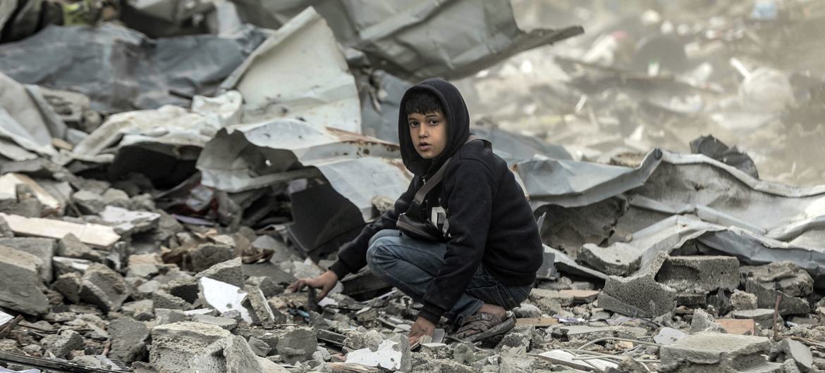 Un niño sentado en los escombros observa la destrucción del barrio Al-Touam en el norte de la Franja de Gaza. Foto Mohammed Natee_UNICEF