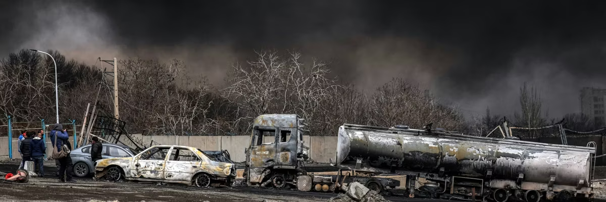 Una nube de humo oscuro envuelve vehículos destruidos cerca de un incendio en curso luego de un ataque aéreo nocturno en la refinería de petróleo de Shahran en el noroeste de Teherán el 8 de marzo de 2026. (Foto de AFP vía Getty Images)